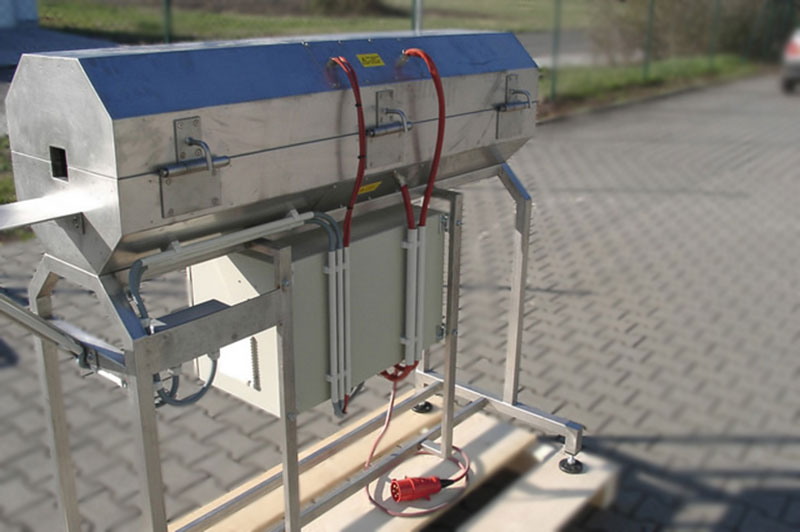 Transition Oven made of stainless steel with a switch box underneath and a hinged upper part for heating an endless steel belt